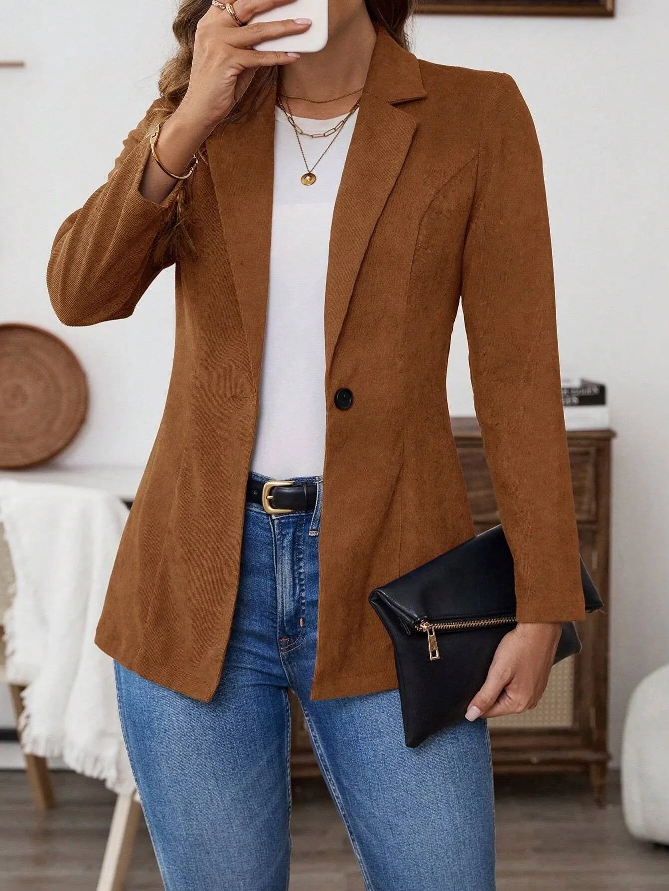 Brown men's single-breasted suit coat with lapels and long sleeves on a hanger
