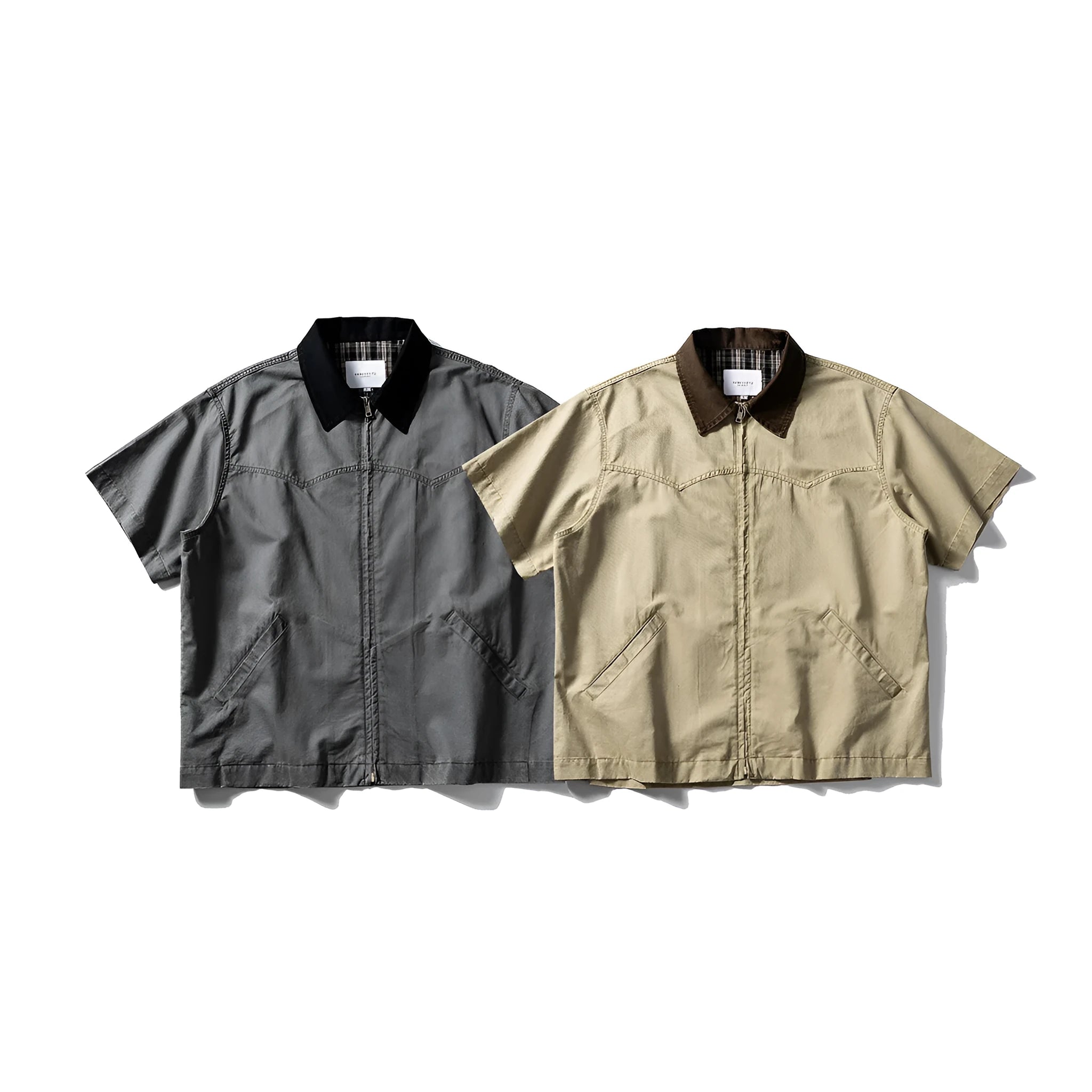 Washed khaki loose-fit cotton overalls shirt with short sleeves on a hanger.
