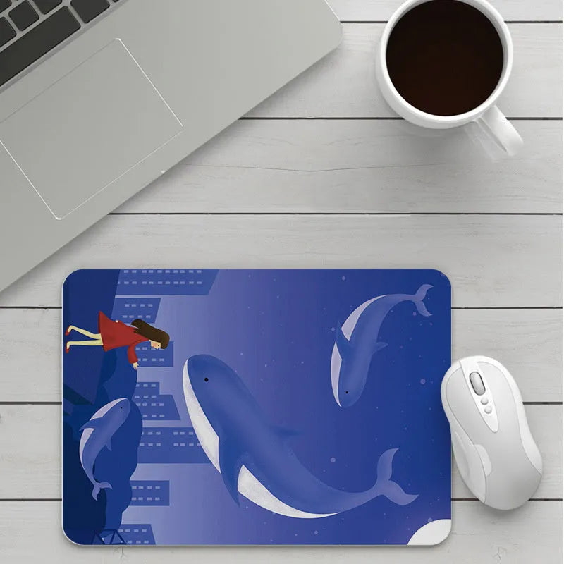 Custom cartoon design on a small black thickened mouse pad with stitching, shown on a desk.