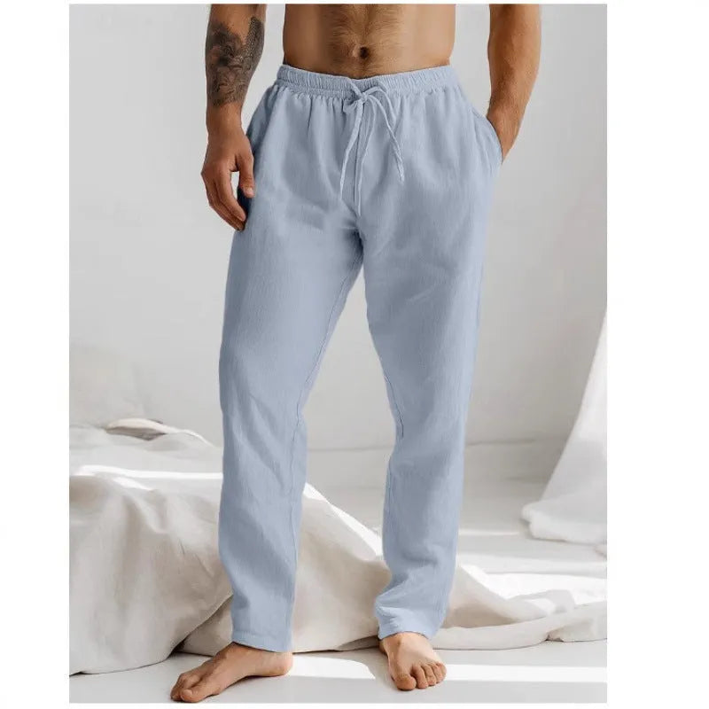 Men's loose straight-leg trousers in light blue with an elastic waistband and drawstring detail.