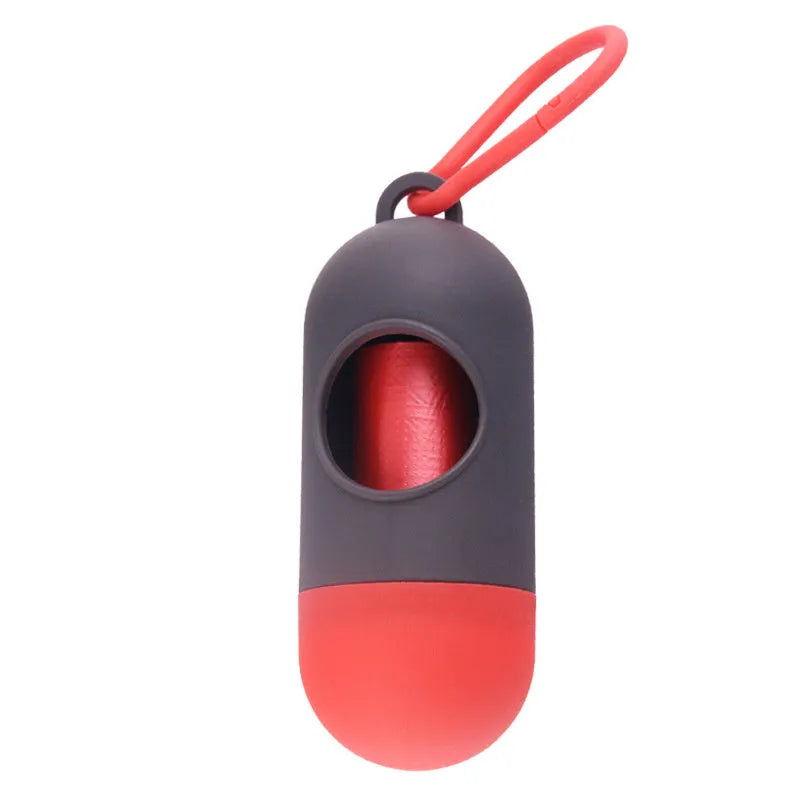 Compact black dog poop bag holder with hook and Velcro strap, shown attached to a pair of trousers.