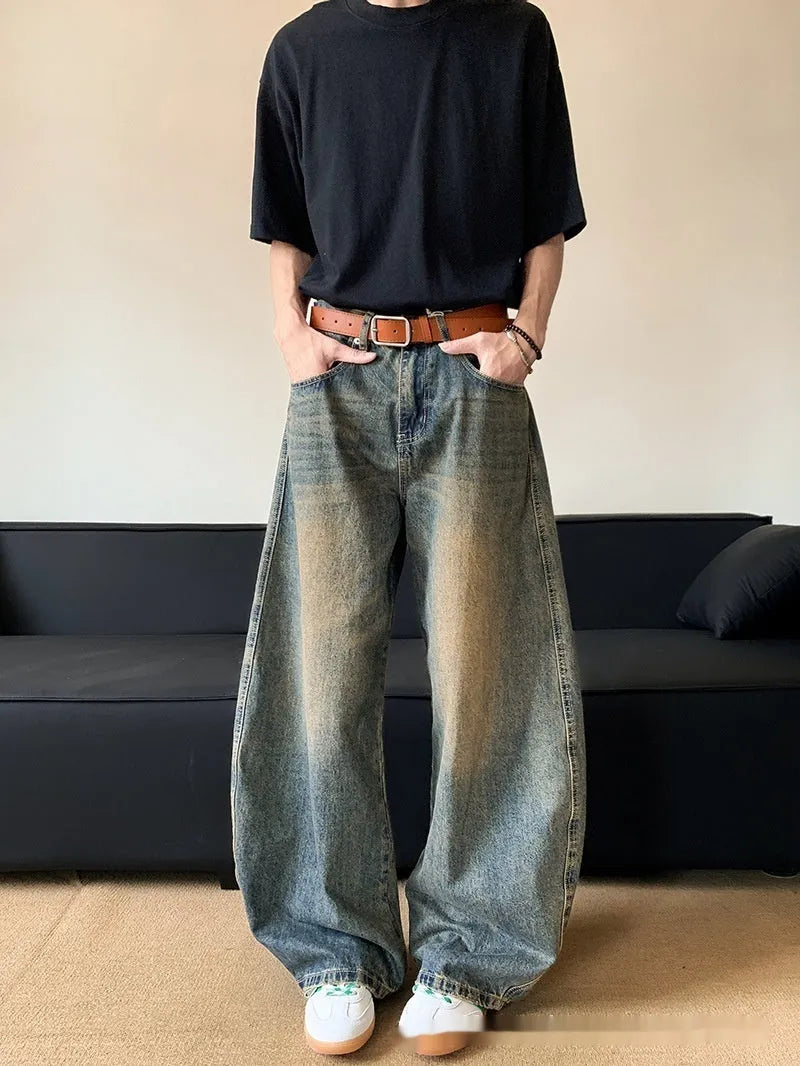 Man wearing retro blue distressed wide-leg denim trousers with a slimming fit.
