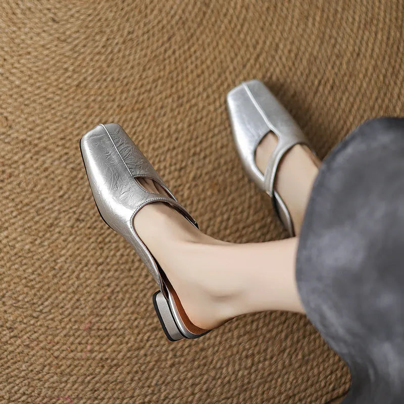 Pair of square-toe casual slippers with a low heel on a rubber sole, shown in a solid colour.
