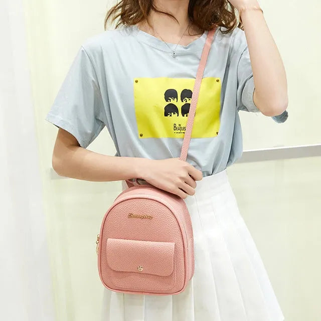 Women's small black PU leather backpack shoulder bag showing front zipper and dimensions