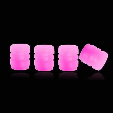 Pack of green and blue luminous rubber tyre valve caps on a car tyre valve.