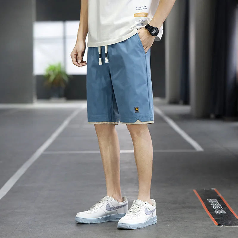 Man's loose-fitting straight-leg beach shorts in green on a neutral background.