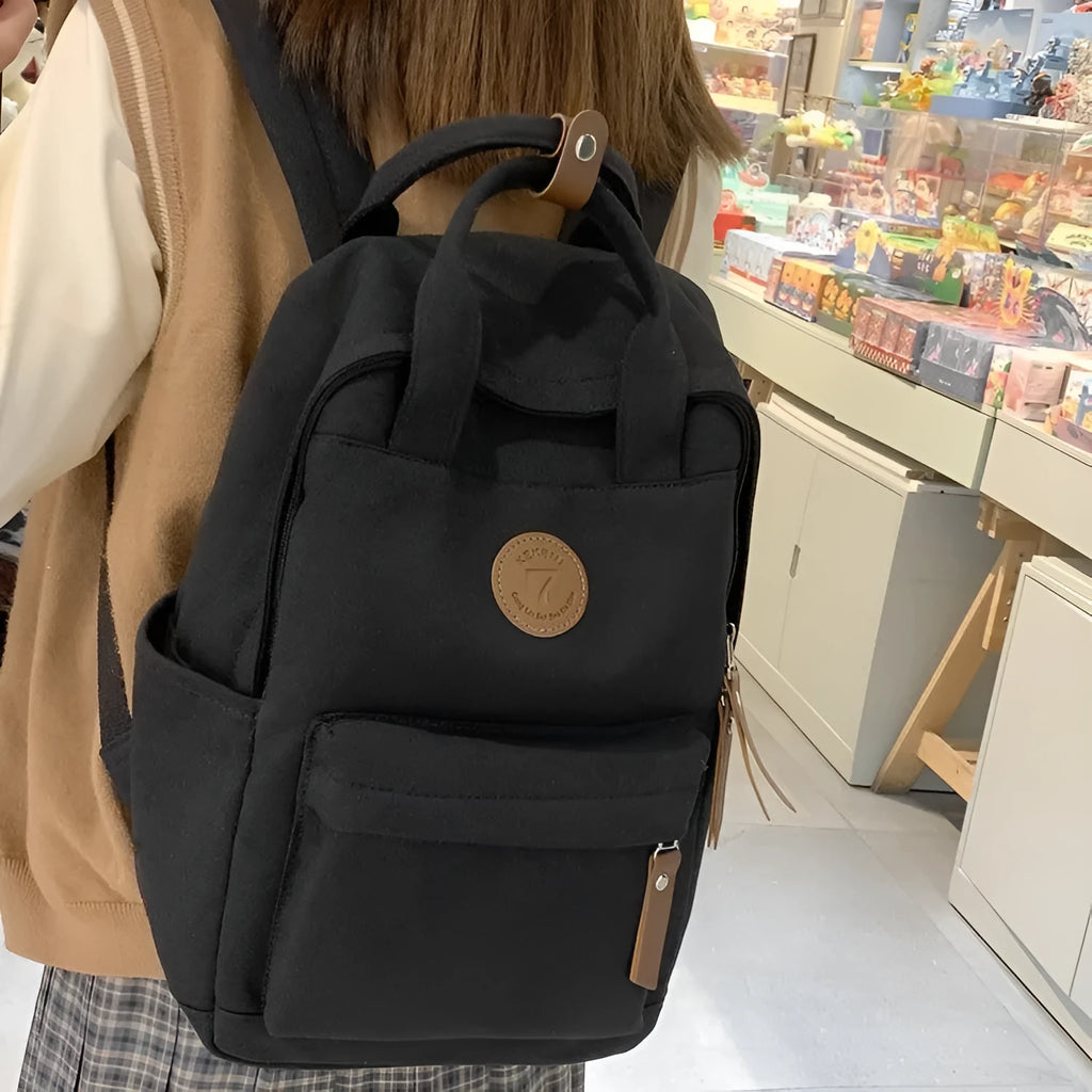 Black Oxford cloth fashion backpack with curved shoulder straps and retro sewing thread details