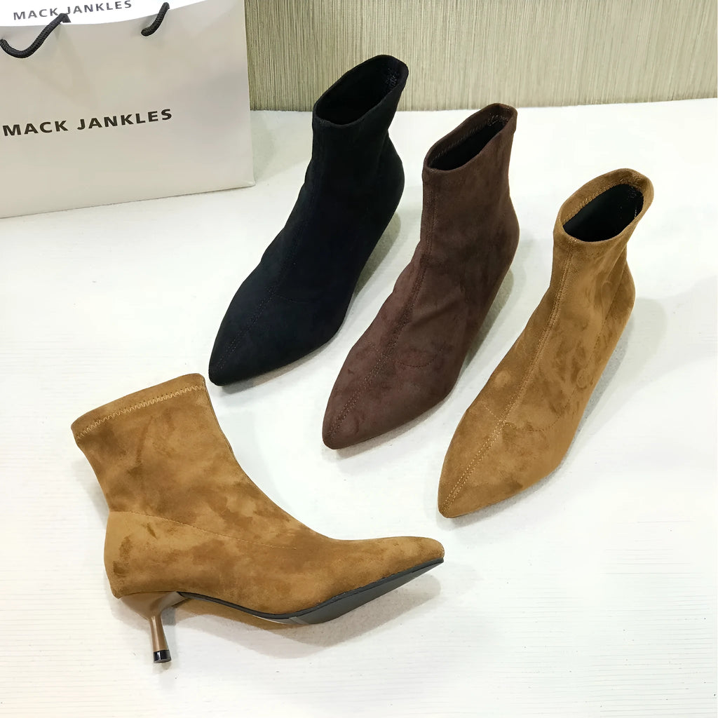 Black pointed toe ankle boots with stiletto heels and mid-calf length
