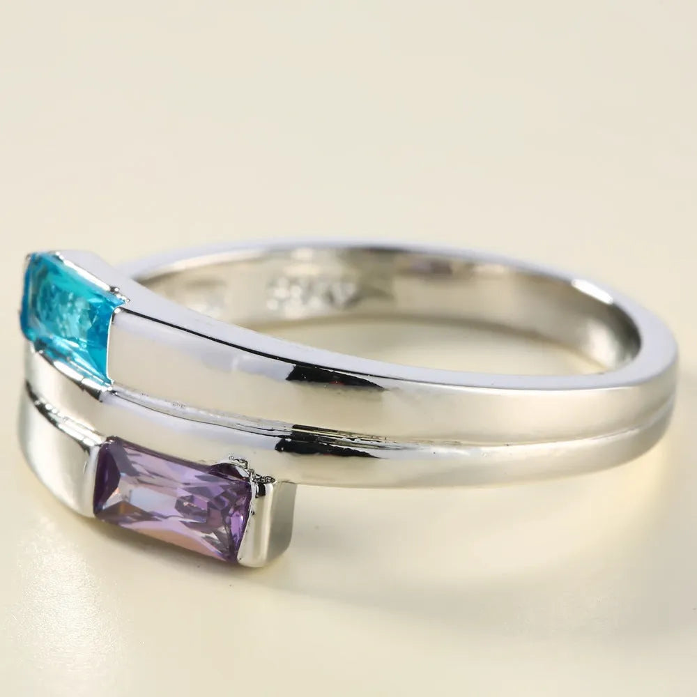 Silver colour copper electroplated ring with inlaid zircon stone on a band