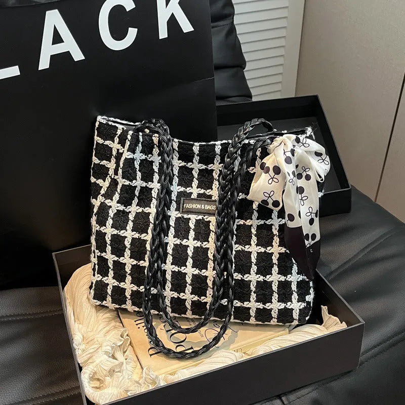 Black woven wool shoulder bag showing internal organisation with phone pocket, document section and zipper compartment