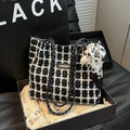 Black woven wool shoulder bag showing internal organisation with phone pocket, document section and zipper compartment