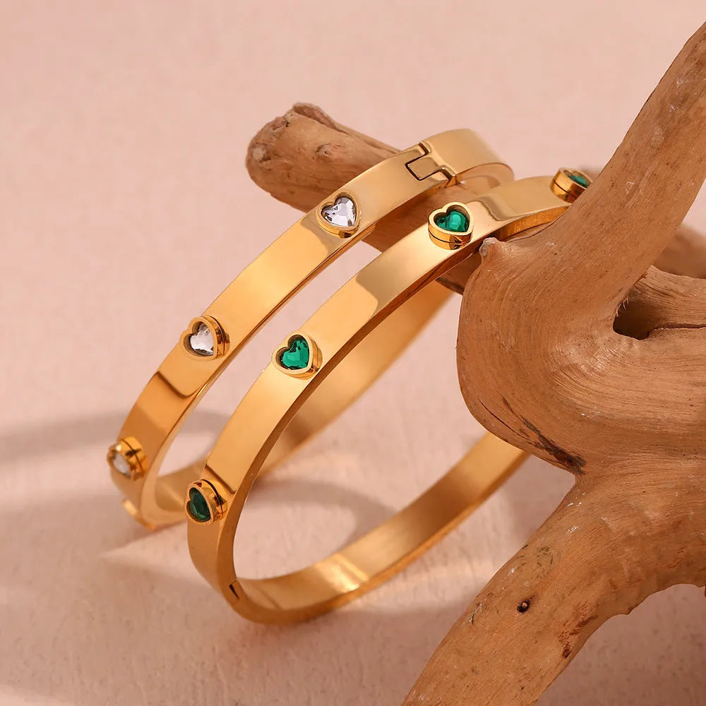 Golden stainless steel bracelet with a small micro-inlaid peach heart pendant.