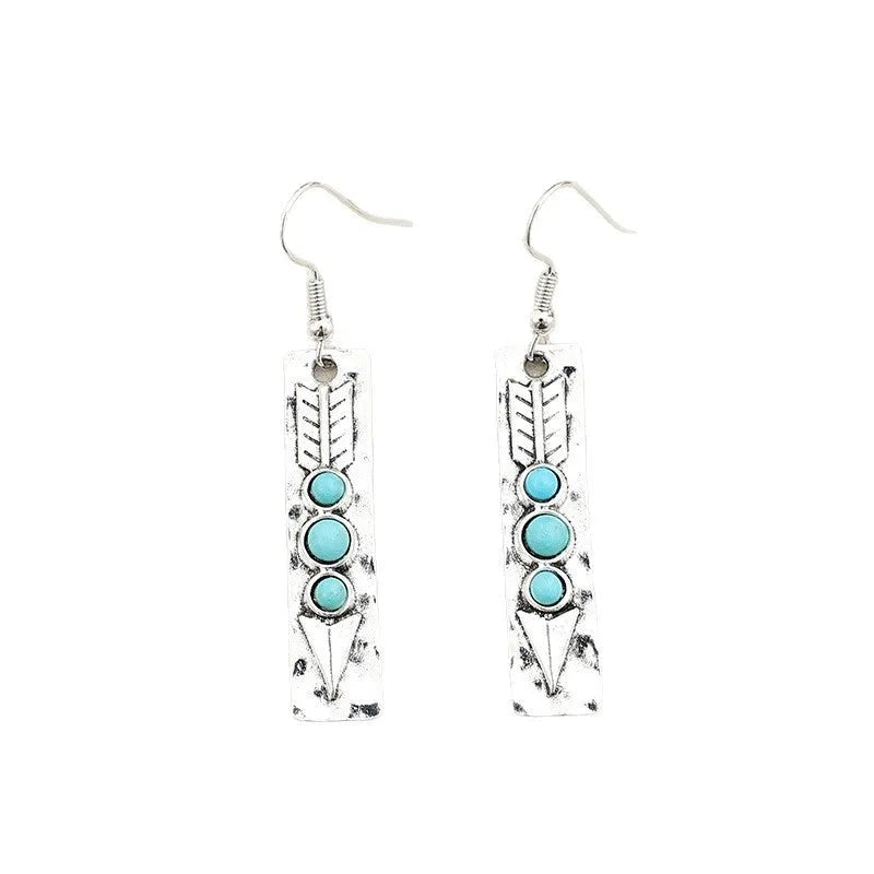 Silver long drop earrings with turquoise inlay and a geometric shape.