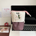 Brown and green cartoon-style collapsible Oxford cloth pencil case showing zip and 17x14cm size.