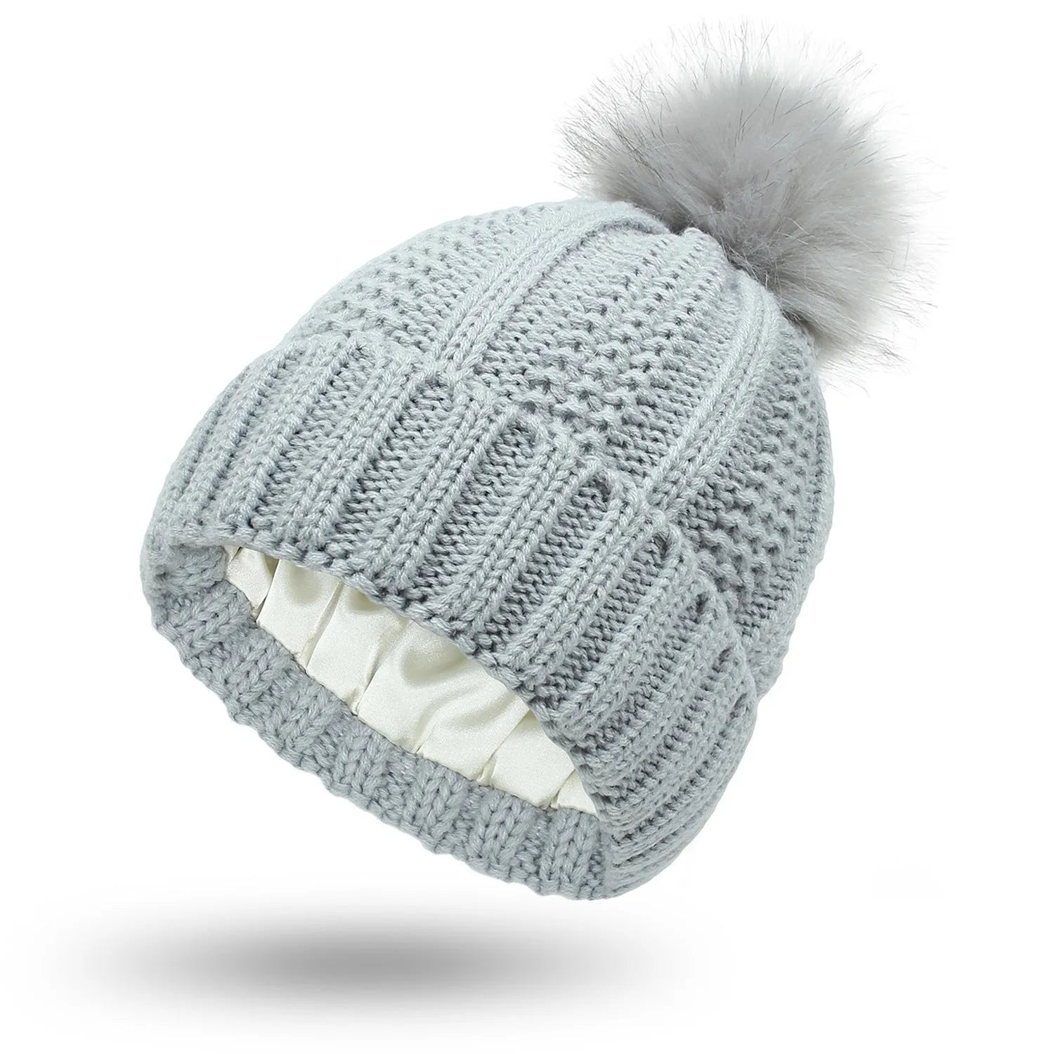 Women's black knit beanie with a faux fur pom pom and satin lining for hair protection