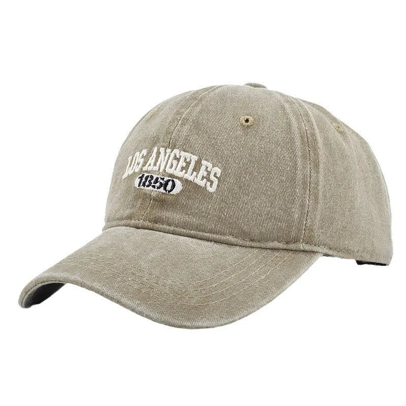 Adult personalised embroidered peaked cap in beige with adjustable strap and distressed lettering.