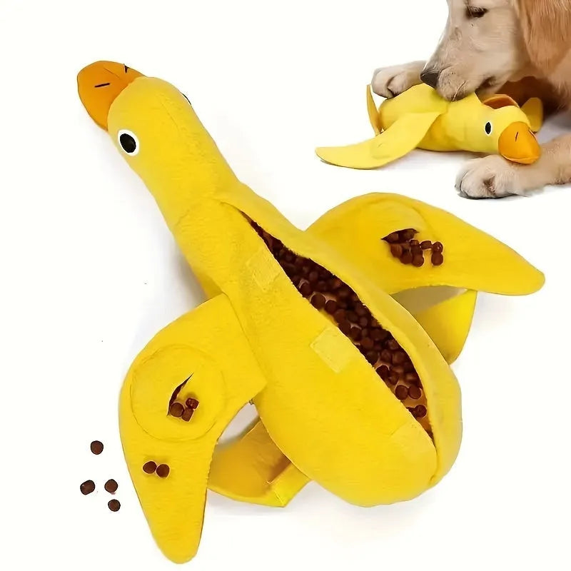 Yellow plush teddy bear dog toy with a small duck doll attached, showing food dispensing holes.