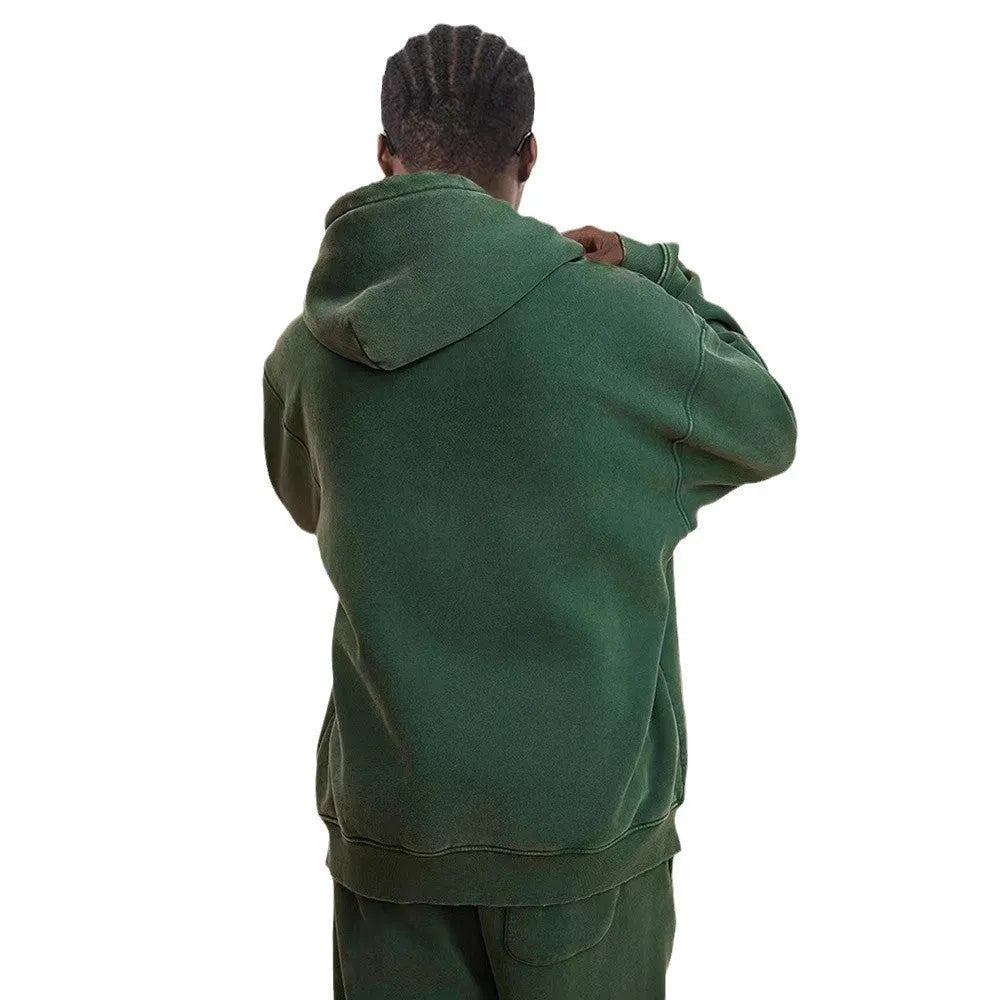 Man wearing a washed black fleece-lined hooded cardigan sweater with a double zip.
