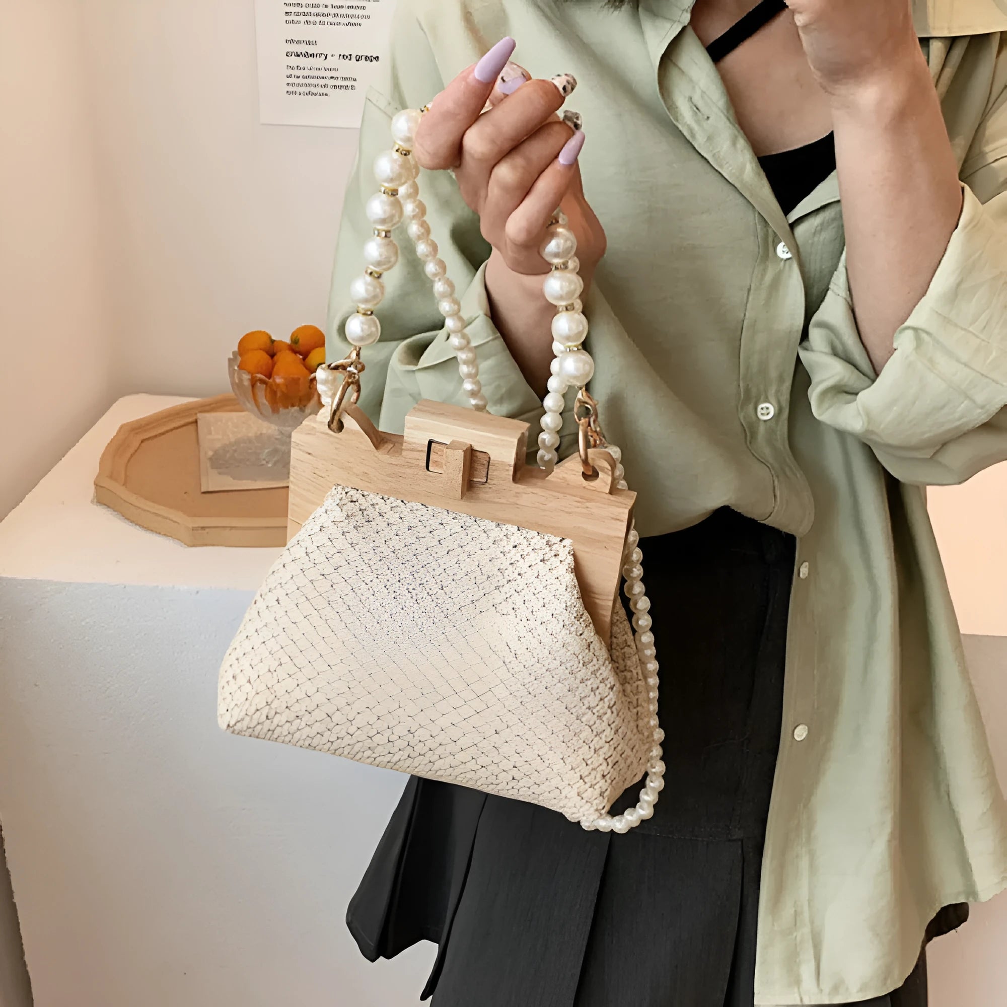 Beige woven straw women's shoulder bag with pearl chain detail, showing interior zipper pockets.