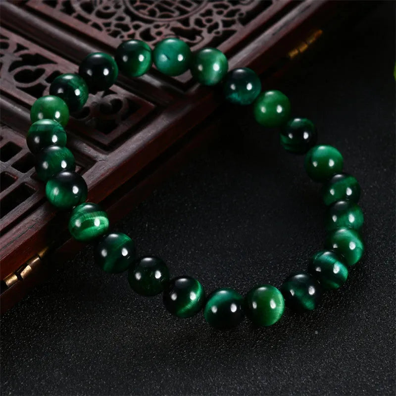 Green Tiger Eye stone beaded bracelet with geometric shaped beads on a wrist.