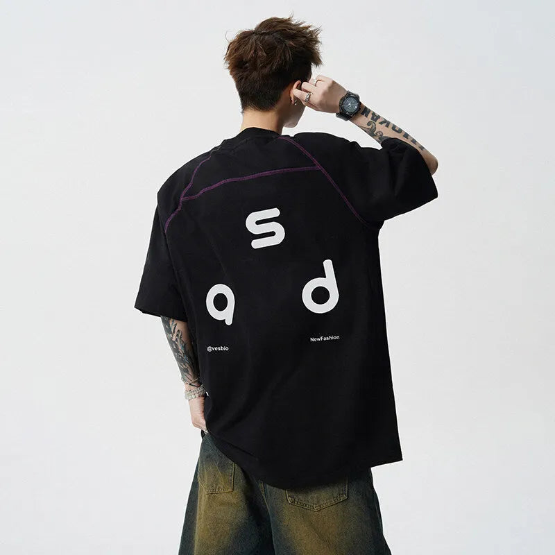 Man wearing a loose-fit black cotton t-shirt with a white letter print on the chest.
