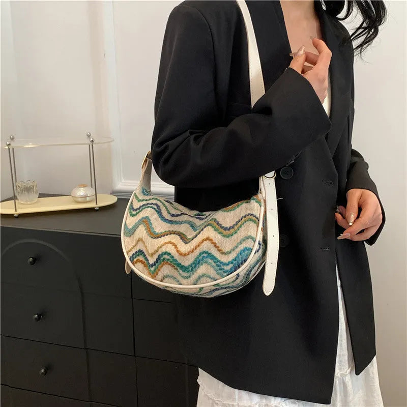 Women's straw woven crossbody bag showing woven texture and internal phone and document compartments