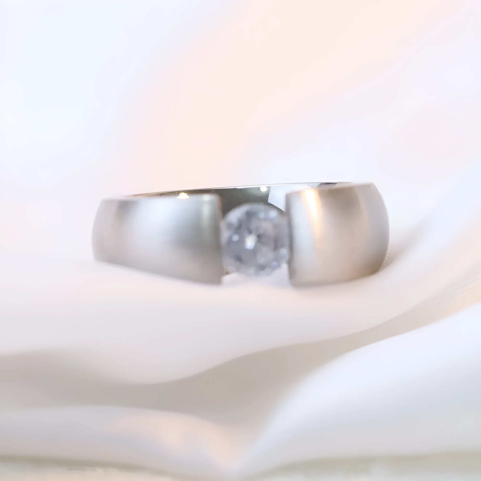 Geometric titanium steel ring with diamond finish in gold colour on a white background