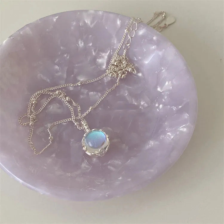 Polished sterling silver necklace for women with round geometric stone pendant on curb chain.