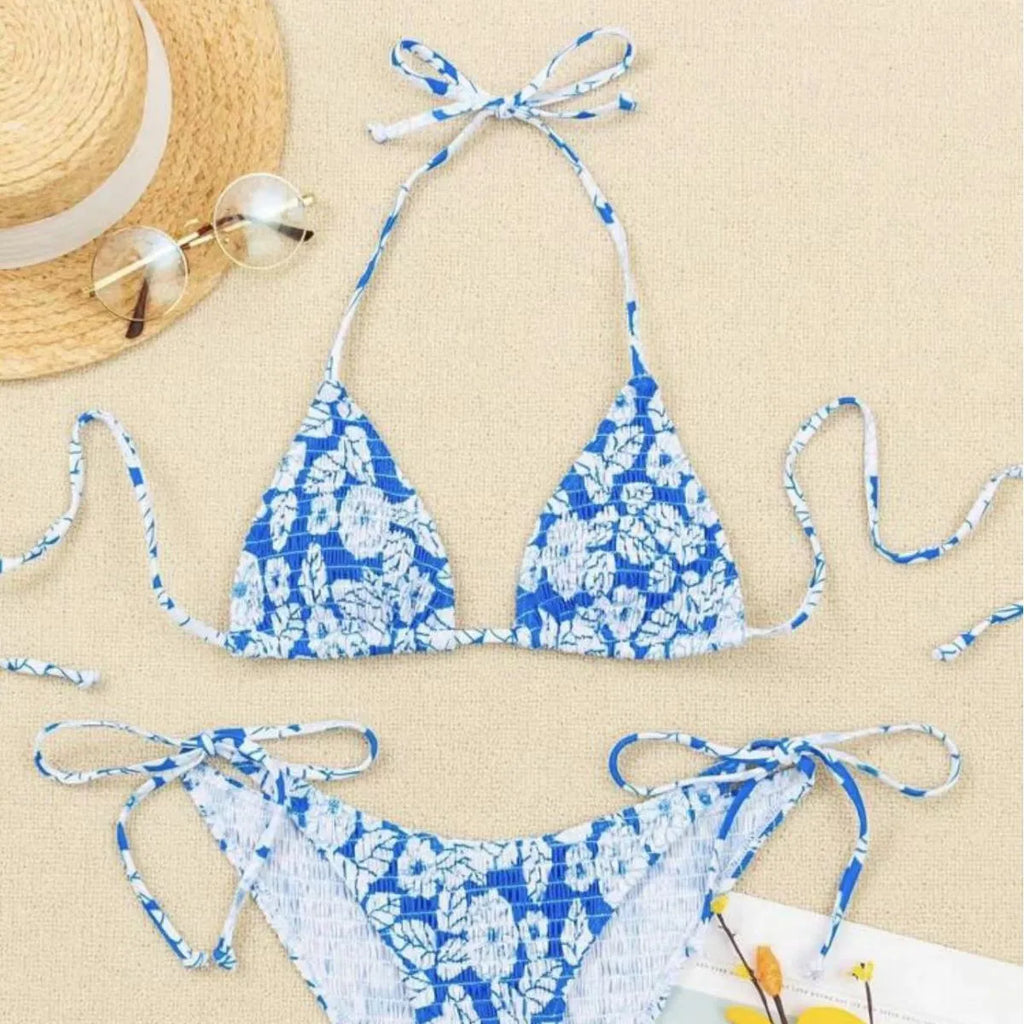 Women's floral print halter neck swimsuit briefs in light blue on a mannequin.