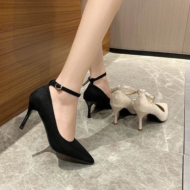 Black women's stiletto heel pump with a buckle detail, shown on a white background.