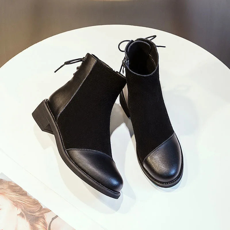 Black women's knee-high martin boots with a side zipper, round toe, and decorative bow.