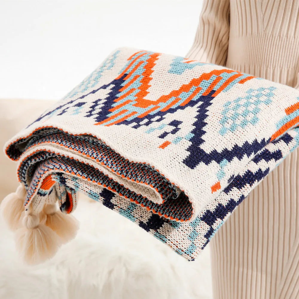 Acrylic sofa blanket with tassels in geometric pattern colour option on a sofa