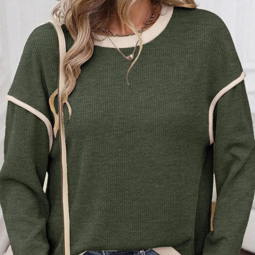 A beige loose knit top with a four leaf clover print and contrasting trim on the sleeves and hem.
