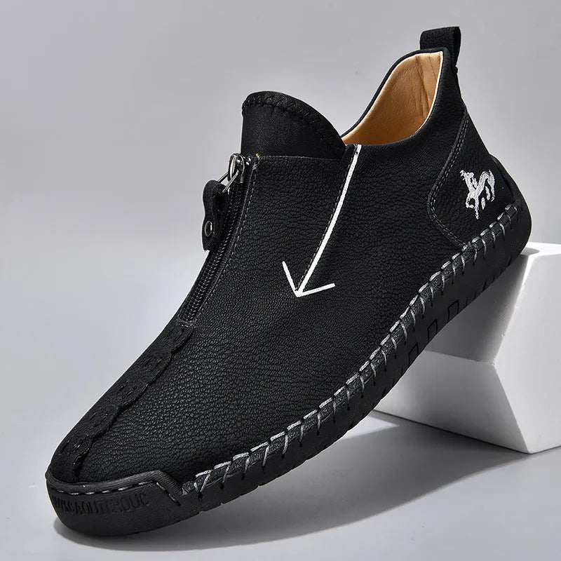 Men's black front-zip casual boots with round toe and low heel, showing the side zipper and rubber sole.