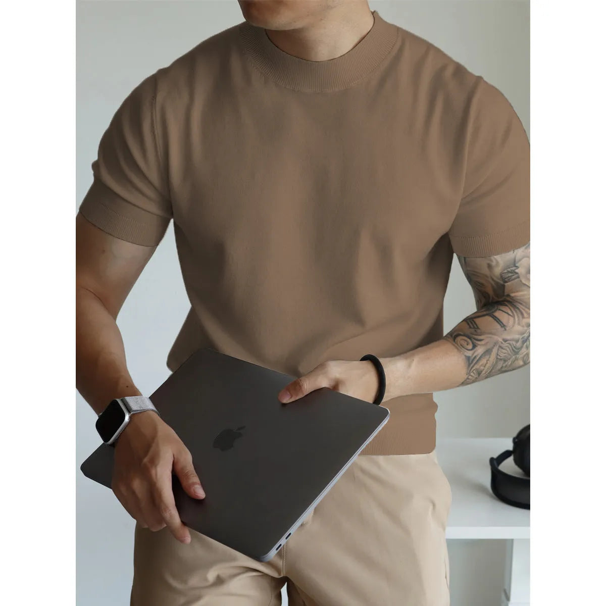 Man wearing a slim-fit solid colour polyester t-shirt, showcasing its lightweight knitwear construction.