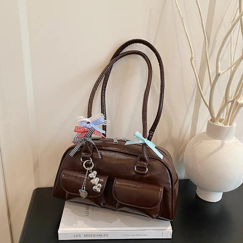 Retro one-shoulder pillow handbag in PU leather, shown in black with a flap closure and double straps.
