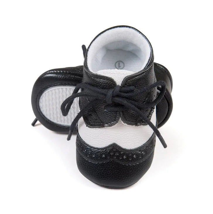 Vintage style soft-soled baby shoes for boys in synthetic leather, available in black, grey, light brown, and white.
