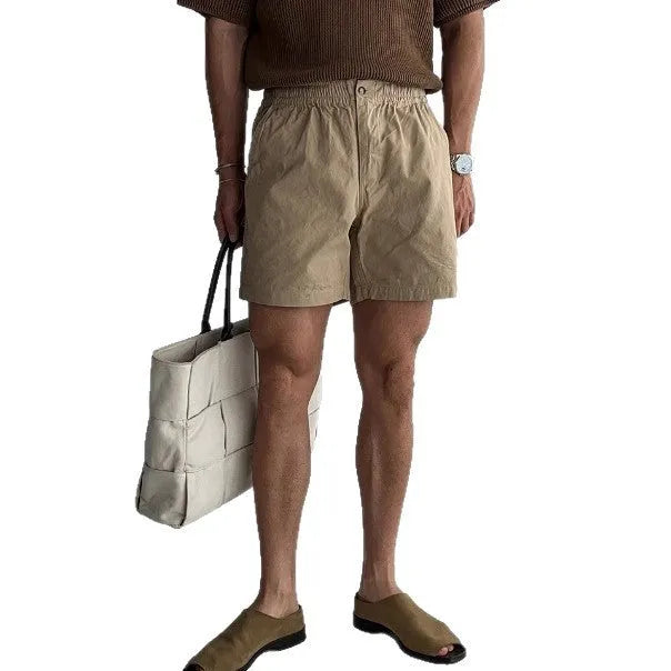 Men's loose-fit cotton sports shorts in khaki colour on a white background.