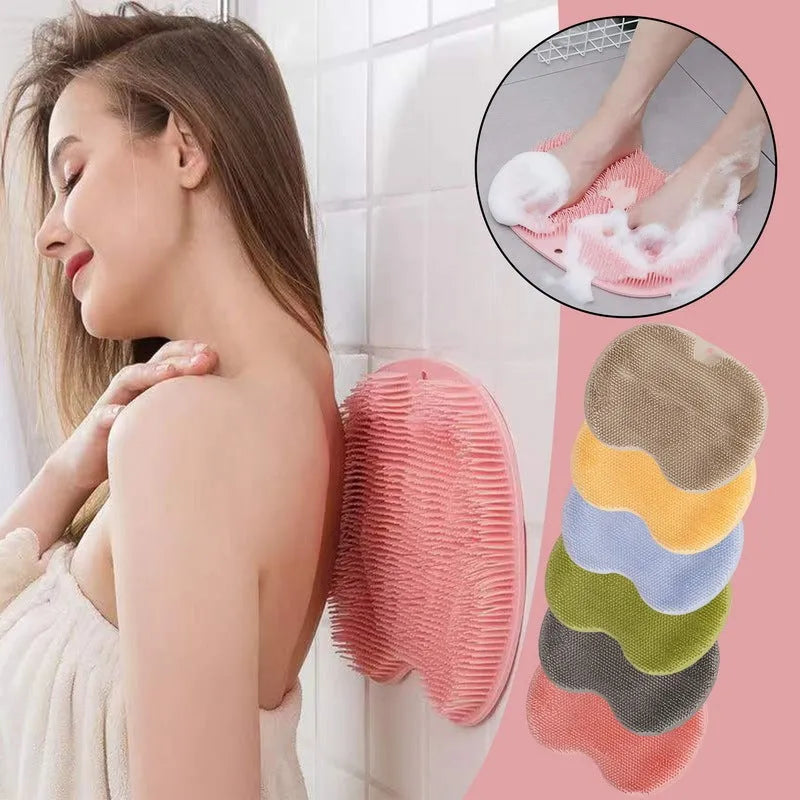 Orange silicone bristle bath brush with suction cup base on a bathroom floor.