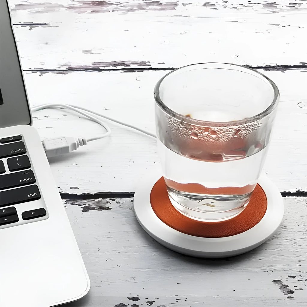 Black USB-powered high temperature heater with insulated base on a desk.