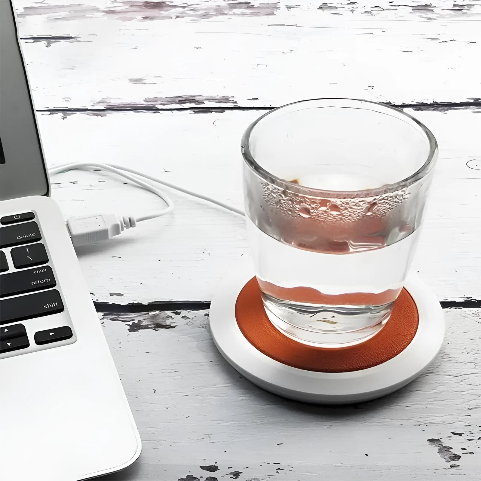 Black USB-powered high temperature heater with insulated base on a desk.