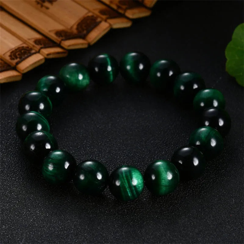 Green Tiger Eye stone beaded bracelet with geometric shaped beads on a wrist.