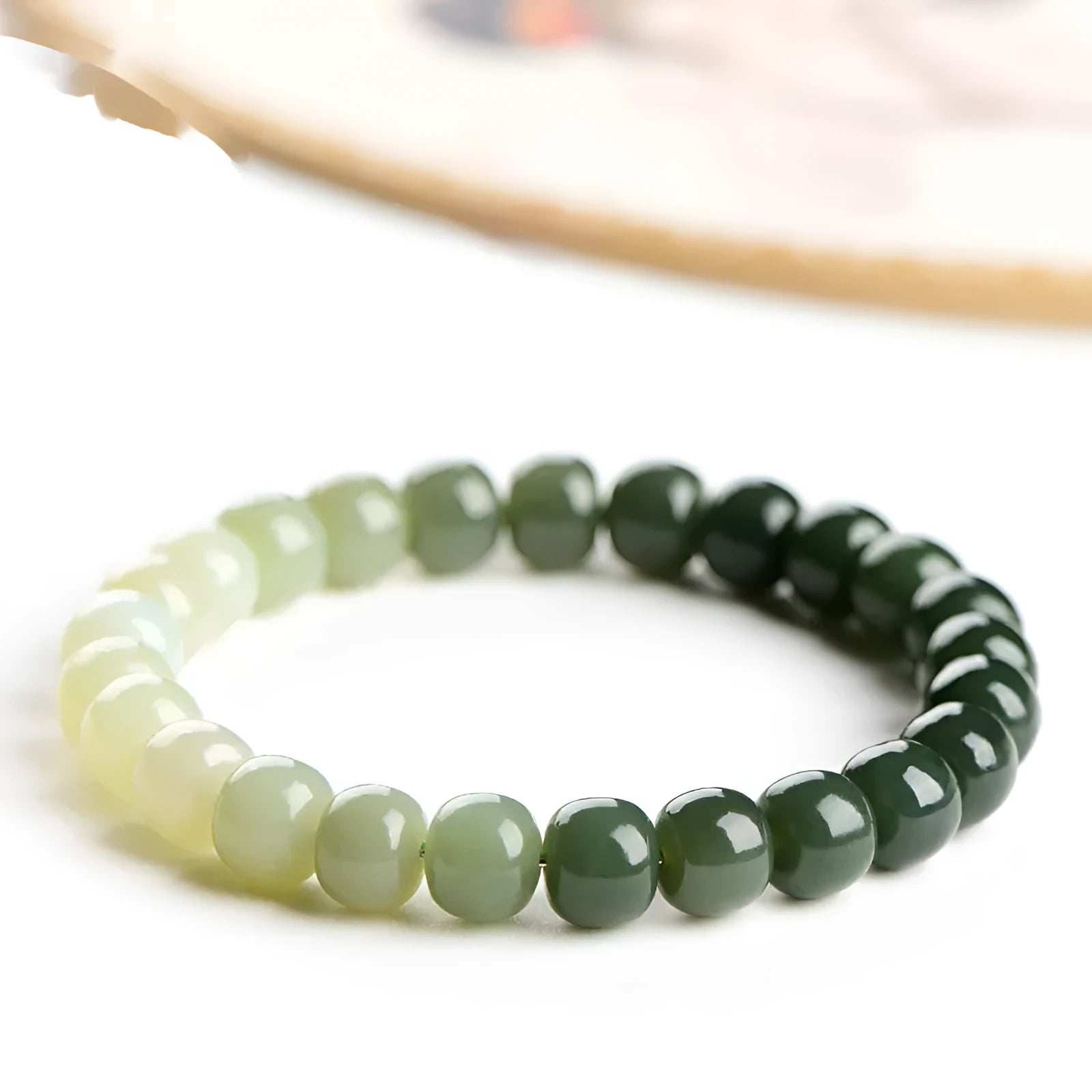 Natural Hetian jade bracelet showing water gradient colour on polished beads.