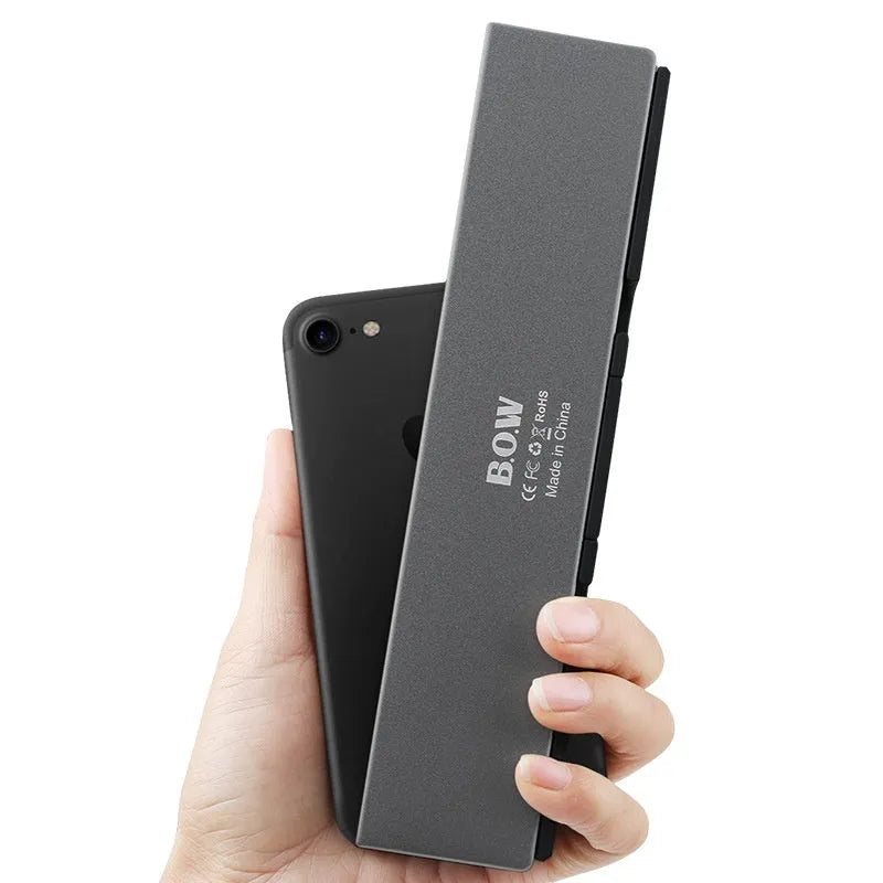 Folding Bluetooth keyboard in black gray for tablets and phones on a plain background