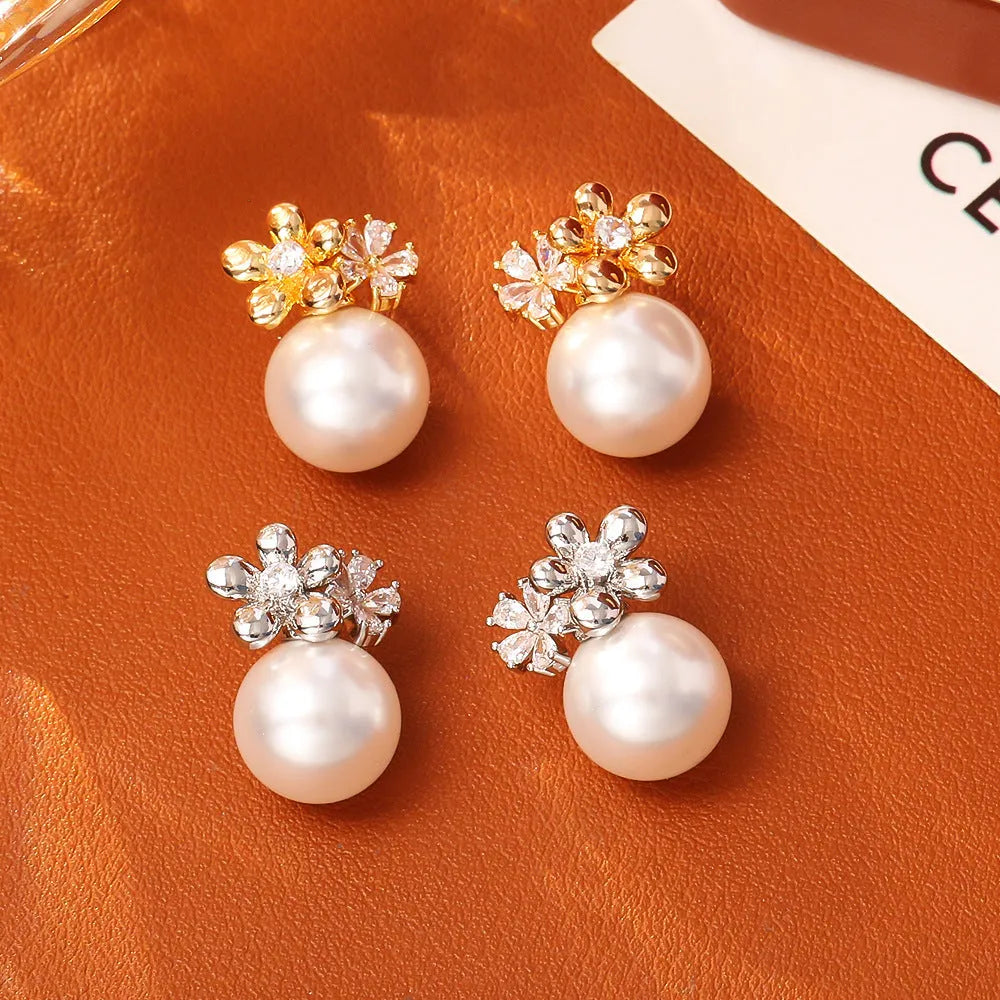 Pair of geometric round pearl and zircon stud earrings in gold plated finish on copper base