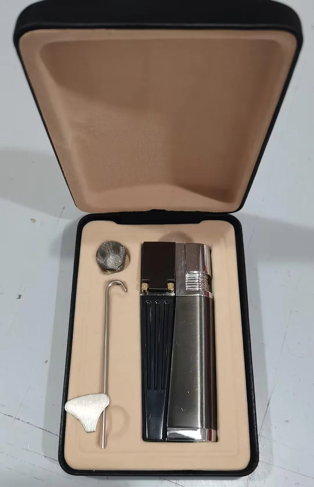 Silver foldable metal pipe lighter shown open, revealing the lighter mechanism and a small stash compartment.