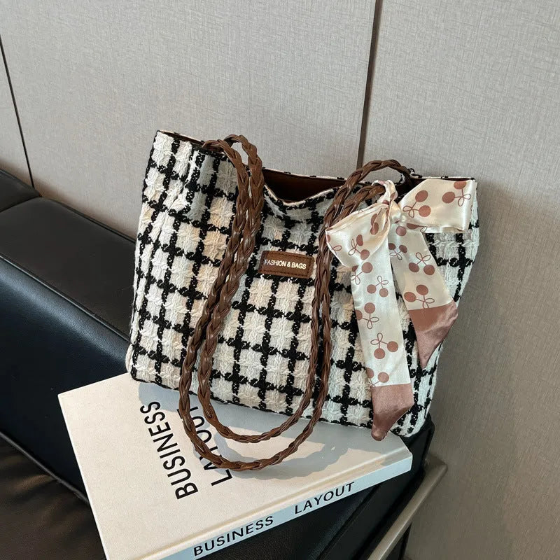 Black woven wool shoulder bag showing internal organisation with phone pocket, document section and zipper compartment