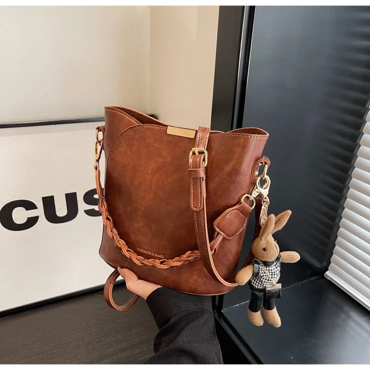 Women's retro bucket messenger bag in PU leather, 21x11x21 cm, with pendant detail and double shoulder strap connector