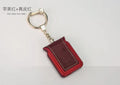 Black leather Bluetooth dual SIM adapter keychain for iOS phones with micro USB port.