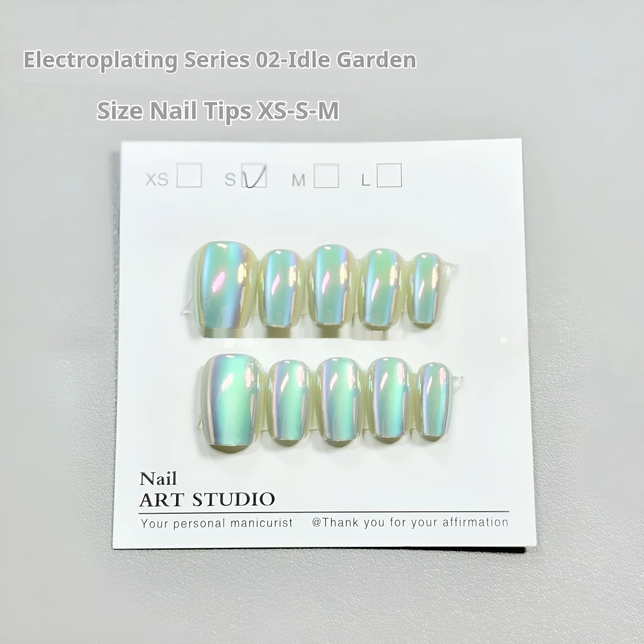Set of electroplated Cat's Eye and aurora design false nails in short ladder XS, S, and M sizes.